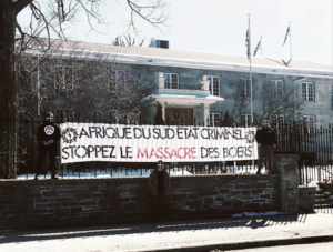 Banderole d'Atalante déployée devant le Haut-commisariat d'Afrique du Sud à Ottawa, mars 2018. À gauche, Shawn Beauvais-MacDonald.